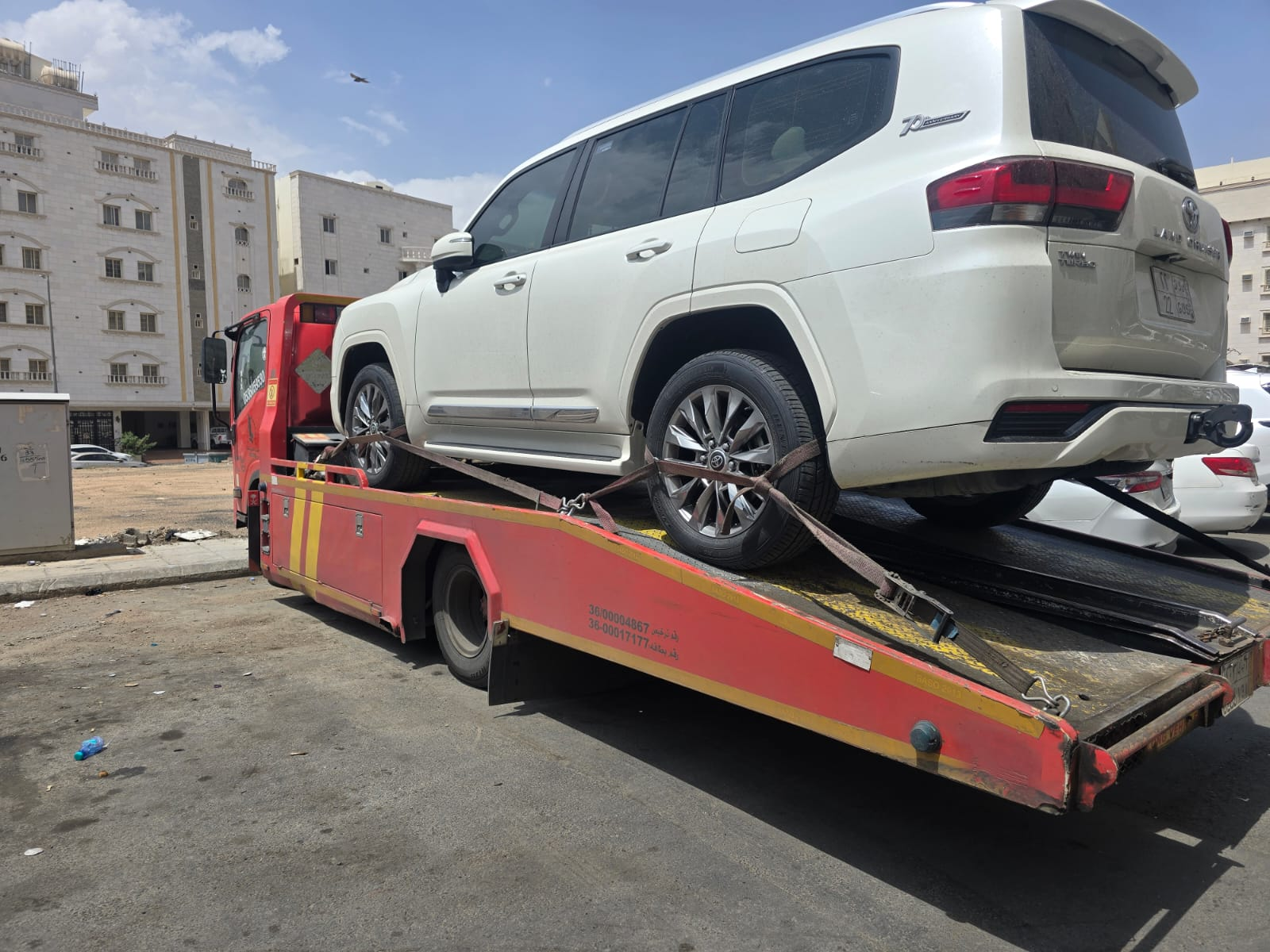 سطحة مغلقة تنقل تويوتا لاندكروزر بيضاء داخل حي سكني بالدمام
