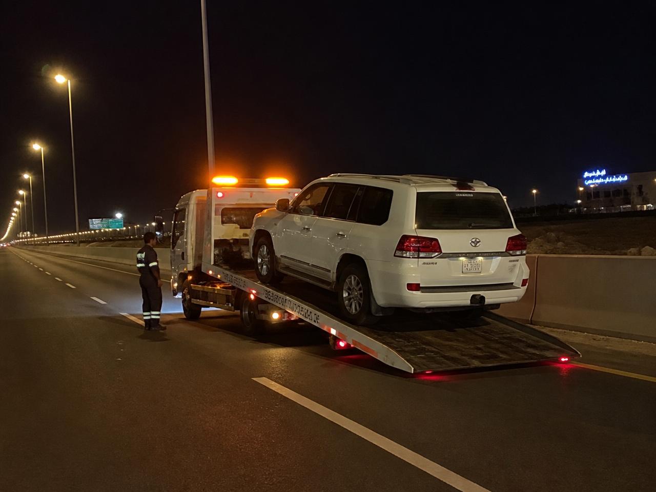 سطحة هيدروليك ليلاً تحمّل سيارة دفع رباعي على الطريق السريع